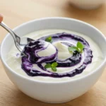 Homemade blue jam garlic aioli recipe with purple swirls in white ceramic bowl